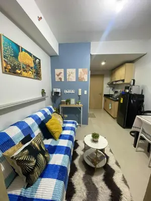 a living room with a blue and white couch and a table at Transient Home Serenity in Manila