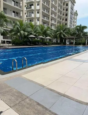 a swimming pool in front of a large building at Calathea Place - Bel's Cozy Staycation in Manila