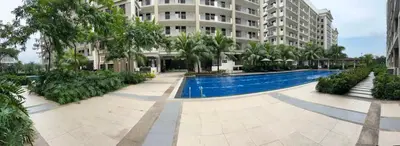 a swimming pool in front of a building at Calathea Place - Bel's Cozy Staycation in Manila