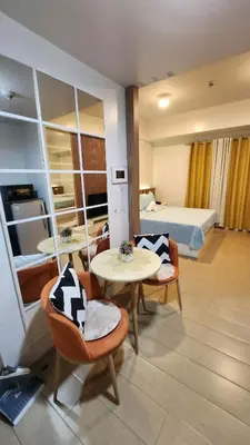 a hotel room with a bed and a table and chairs at 10P North Wing in Manila