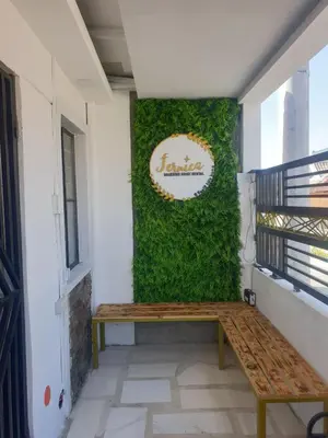 a bench sitting in front of a green wall at Fernica Boarding House in Carmona