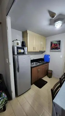 a kitchen with a refrigerator and a sink in it at 4V North Wing in Manila