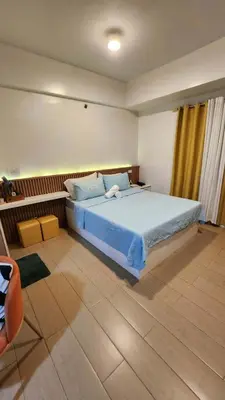 a bedroom with a large bed with blue sheets at 4V North Wing in Manila