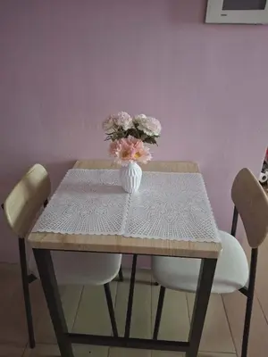 a wooden table with a vase of flowers on it at 4V North Wing in Manila