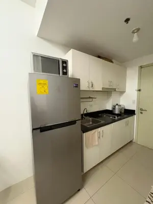 a kitchen with a refrigerator and a microwave at Condomatch Staycation in Manila