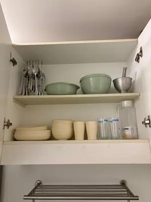 a shelf with bowls and other kitchen utensils at Condomatch Staycation in Manila