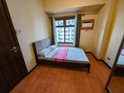 a small bedroom with a bed and a window at Moonsky Suites in Manila