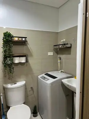 a bathroom with a white toilet and a sink at Althalia Grandsuites Staycation in Manila