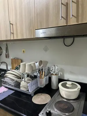 a kitchen counter with plates and utensils on a tray at Althalia Grandsuites Staycation in Manila