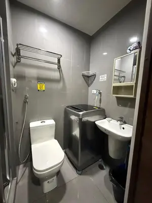 a small bathroom with a toilet and a sink at Relaxing Escape 2 Beds Rattan Chair & 65 inch Smart TV in Manila