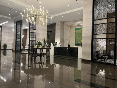 a lobby with a chandelier and a table in it at Modern 1 BR Condo near Airport, MOA, PICC, Star City, OKADA With Fast WIFI & Netflix Free Pool Access in Sampong