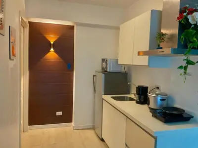 a kitchen with a counter and a door with a clock at Azure staycation miami tower in Manila