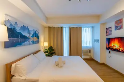 a bedroom with a white bed with a cross on it at Azure staycation miami tower in Manila