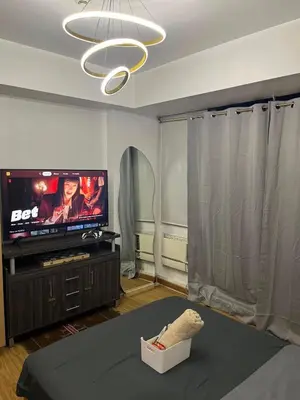 a living room with a flat screen tv and a couch at Azure Urban Resort Residences by JEs Cabin in Manila