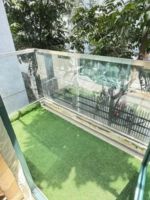 a balcony with green grass and a fence at Palme d'Or Stay in Manila