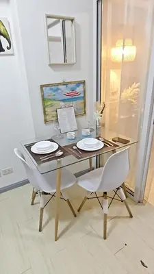 a dining room table with two chairs and a glass table at The Infinity Staycation in Manila