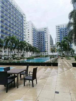 a patio with a table and chairs and buildings at Sea Residences Wenda in Manila
