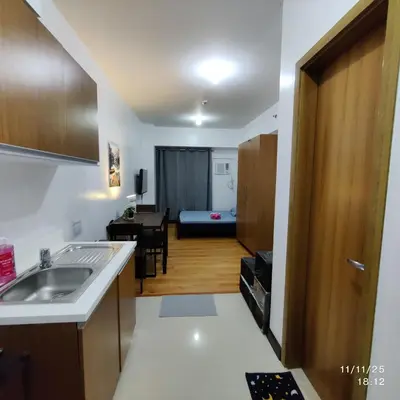 a kitchen with a sink and a living room at 8Adriatico Condo near US Embassy in Manila