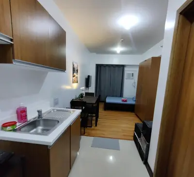 a kitchen with a sink and a living room at 8Adriatico Condo near US Embassy in Manila