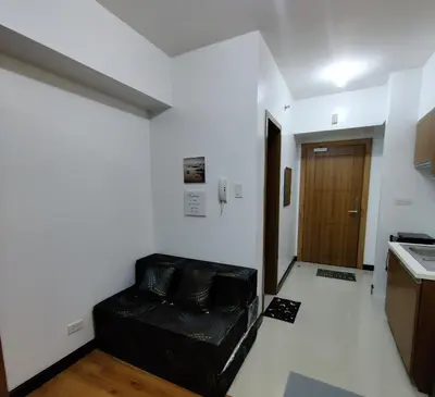 a living room with a black couch in a room at 8Adriatico Condo near US Embassy in Manila