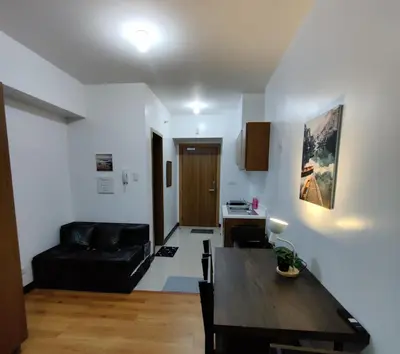 a living room with a black couch and a table at 8Adriatico Condo near US Embassy in Manila