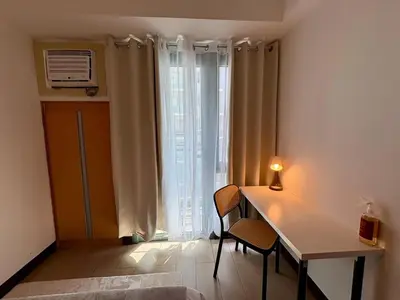 a room with a table and chairs and a window at Warm & Minimalist 1BR at Two Palm, Newport, T3 in Manila