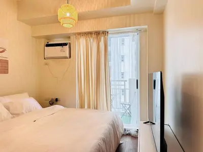 a bedroom with a bed and a window at The K-Butter Lounge by Kozy Mood near BGC in Manila