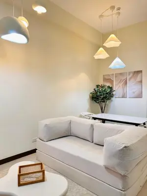a living room with a white couch and a table at Cloud Cinema by Kozy Mood near BGC in Manila