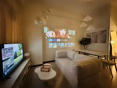 a living room with a couch and a flat screen tv at Cloud Cinema by Kozy Mood near BGC in Manila