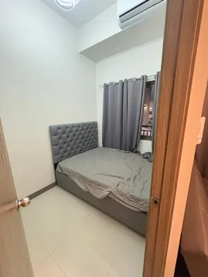 a small bedroom with a bed and a window at S Residences pool side 3 in Manila