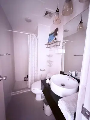a white bathroom with a sink and a toilet at Luxurious Taguig Apartment with Private Pool and Central AC in Manila