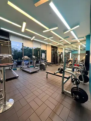 a gym with a large room with cardio equipment at Luxurious Taguig Apartment with Private Pool and Central AC in Manila