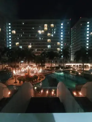 a view of a city at night with lights at Classy Pool view low floor Condo near MoA in Manila