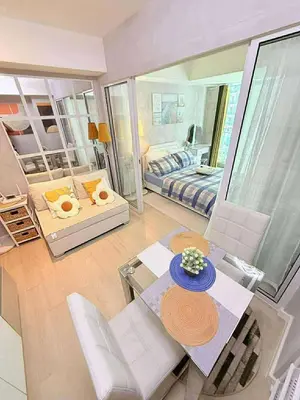 a living room with a dining table and a bedroom at Condotels Villa Topaz in Manila