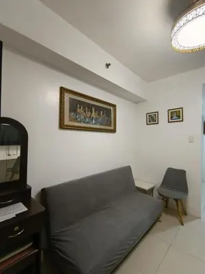 a living room with a couch and a tv at Sea Residences MOA Area in Pasay City in Manila