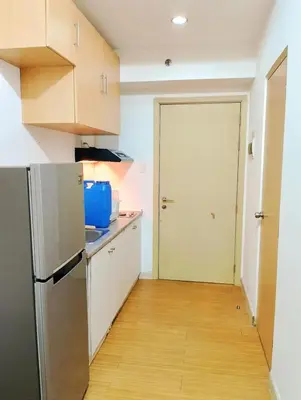 a kitchen with white cabinets and a refrigerator at Penguin Hotel in Manila