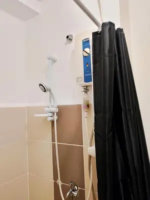 a shower with a black shower curtain in a bathroom at Penguin Hotel in Manila