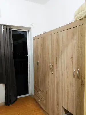 a wooden cabinet with a sliding door in a room at Penguin Hotel in Manila