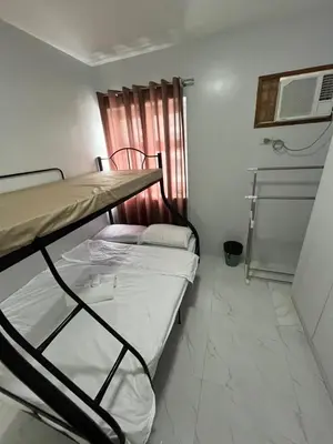 two bunk beds in a small room with a window at Antel Spa Residences 1710 in Manila