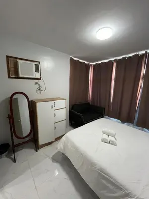 a bedroom with a bed and a mirror and a chair at Antel Spa Residences 1710 in Manila