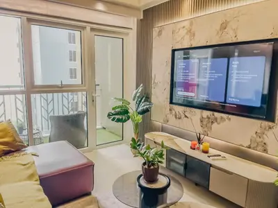 a living room with a couch and a tv at Spacious & Luxury 4BR Home across Okada and Solaire in Manila