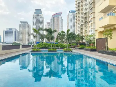 a swimming pool with a city skyline in the background at Cozy BB in the Heart of Quezon City in Manila