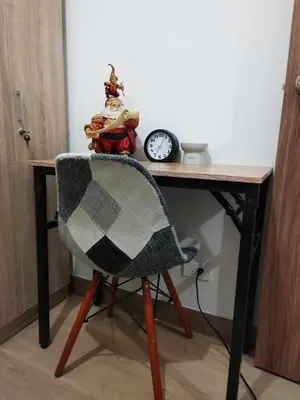 a desk with a chair and a clock on it at Metro Home Staycation in Manila