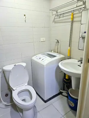 a bathroom with a toilet and a sink at Nest & Rest by RanDecz in Manila