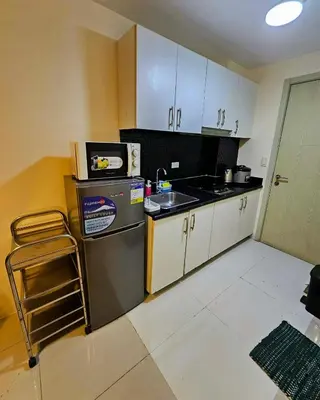 a small kitchen with a sink and a refrigerator at Nest & Rest by RanDecz in Manila