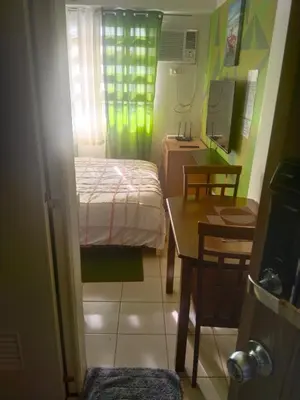 a small room with a bed and a table and a desk at Nicecondotel in Manila