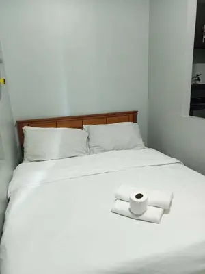 a white bed with two rolls of toilet paper on it at Stamford Executive Residences, McKinley Hill in Manila