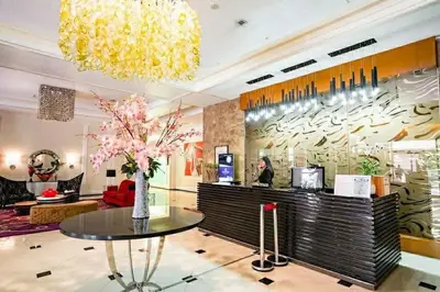 a lobby with a table with a vase of flowers at Stamford Executive Residences, McKinley Hill in Manila