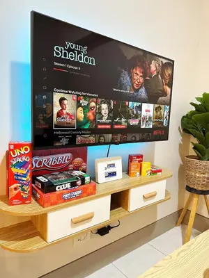 a flat screen tv sitting on top of a tv stand at Cozy Modern Condo in Little Baguio Terraces San Juan City in Manila