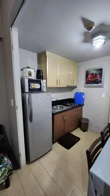 a kitchen with a stainless steel refrigerator and a counter at Your Home Suite at 150 Newport Boulevard Condo near NAIA T3 in Manila